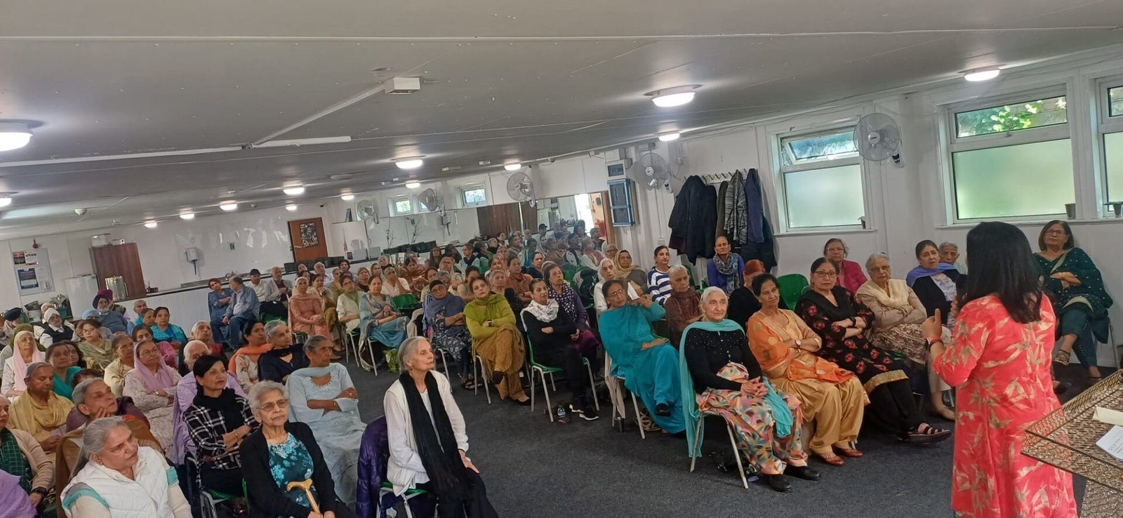 Wide view of people listening to a presentation in a meeting room
