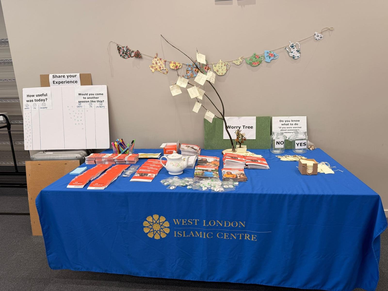 Table covered in blue table cloth displaying lots of leaflets and materials